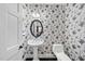 Stylish powder room featuring decorative wallpaper, pedestal sink, and a black framed mirror at 6212 Trevor Ct, Raleigh, NC 27613