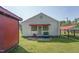 Charming home exterior featuring a cozy front porch with seating, and a well-maintained lawn at 729 S Carolina Ave, Henderson, NC 27536