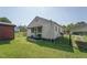 Exterior view of the home features a covered front porch, storage shed, and a lush green lawn at 729 S Carolina Ave, Henderson, NC 27536