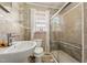 Stylish bathroom features a walk-in shower with glass door, floating glass shelves, and neutral tile at 729 S Carolina Ave, Henderson, NC 27536