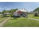 Exterior view of home featuring lawn, carport, and beautiful landscaping at 729 S Carolina Ave, Henderson, NC 27536