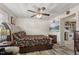 Comfortable main bedroom with decorative bed frame, ceiling fan, TV, and view of the kitchen at 729 S Carolina Ave, Henderson, NC 27536