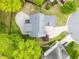 An aerial view showcasing the roofline, large backyard, patio, and surrounding lush landscape at 733 Holding Ridge Ct, Wake Forest, NC 27587