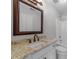 Bathroom vanity featuring granite countertops, a framed mirror, and a white tub at 733 Holding Ridge Ct, Wake Forest, NC 27587