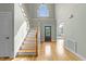 Bright foyer with hardwood floors, staircase, and a view of the dining room and front door, creating a grand entrance at 733 Holding Ridge Ct, Wake Forest, NC 27587
