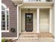 Welcoming front porch with classic details, including white columns, a brick landing, and a charming front door at 733 Holding Ridge Ct, Wake Forest, NC 27587