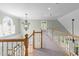 View of hallway with wood banisters, carpet flooring, arched window, and chandelier at 733 Holding Ridge Ct, Wake Forest, NC 27587
