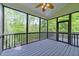 Screened porch with wood floors and ceiling fan overlooking a green and wooded backyard at 733 Holding Ridge Ct, Wake Forest, NC 27587