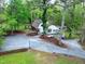 Aerial view of the home showing the home's serene, private wooded lot, circular drive, and covered outdoor space at 831 Healey Ln, Durham, NC 27705