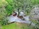Aerial view of the house surrounded by a lush landscape of mature trees and a gravel driveway at 831 Healey Ln, Durham, NC 27705
