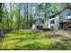 Large backyard with a wooden deck, green grass and mature trees at 831 Healey Ln, Durham, NC 27705