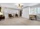 Bright bonus room features a murphy bed, desk, ceiling fan, neutral paint and carpet, and comfortable chairs at 831 Healey Ln, Durham, NC 27705
