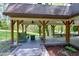 Relaxing covered deck with comfortable seating, offering a tranquil view of the surrounding wooded landscape at 831 Healey Ln, Durham, NC 27705