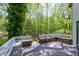 Well-maintained wooden deck with integrated seating, offering a relaxing outdoor space surrounded by trees at 831 Healey Ln, Durham, NC 27705