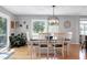 Sunlit dining area featuring a contemporary light fixture and views of the private backyard and deck at 831 Healey Ln, Durham, NC 27705