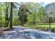Scenic view of a winding gravel driveway leading to a picturesque home surrounded by trees at 831 Healey Ln, Durham, NC 27705