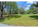 Lush green front yard with mature trees, offering privacy and a serene setting at 831 Healey Ln, Durham, NC 27705