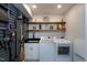 Well-organized laundry room with washer, dryer, utility sink, shelving, and storage at 831 Healey Ln, Durham, NC 27705