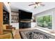 Cozy living room with fireplace, built-ins, and a large window showcasing the private, wooded backyard at 831 Healey Ln, Durham, NC 27705