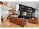 Living room with hardwood floors, built-in shelving, staircase, and leather couches at 831 Healey Ln, Durham, NC 27705