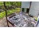Aerial view of stone patio with fire pit and seating, connecting seamlessly with the natural surroundings at 831 Healey Ln, Durham, NC 27705