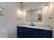 Chic powder room with patterned wallpaper, blue vanity, and stylish lighting at 831 Healey Ln, Durham, NC 27705