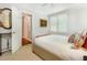 Sunlit bedroom boasts neutral colors, a window with blinds, and a decorative mirror above a small table at 8805 Mourning Dove Rd, Raleigh, NC 27615
