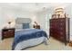 Bedroom featuring soft blue accents, a tall dresser and bedside tables with lamps at 8805 Mourning Dove Rd, Raleigh, NC 27615