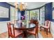 Elegant dining room with dark blue walls, chandelier, and large bay window with patterned curtains at 8805 Mourning Dove Rd, Raleigh, NC 27615