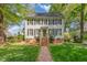 Charming two-story home with black shutters, a brick foundation, and a brick walkway leading to the front door at 8805 Mourning Dove Rd, Raleigh, NC 27615