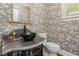 Unique powder room featuring an ornate mirror, black bowl sink, and decorative wallpaper at 8805 Mourning Dove Rd, Raleigh, NC 27615