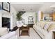 Comfortable living room with a fireplace, hardwood floors, neutral furniture, and a view into the kitchen and staircase at 97302 Dobbs, Chapel Hill, NC 27517