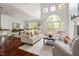 Open-concept living room with high ceilings, large windows, hardwood floors, and comfortable seating near a dining area at 97302 Dobbs, Chapel Hill, NC 27517