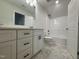 Bright bathroom featuring a white vanity with quartz countertops, a shower-tub combo, and stylish tiled floors at 1008 Peedin Rd, Selma, NC 27576