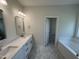 Bathroom featuring double vanity sinks, tub, and hexagon tile flooring at 1008 Peedin Rd, Selma, NC 27576