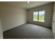 Empty bedroom with neutral carpet and a large window providing outdoor views at 1008 Peedin Rd, Selma, NC 27576