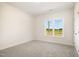 Bedroom with neutral carpet and light walls features a window overlooking a green field at 1008 Peedin Rd, Selma, NC 27576