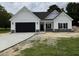 Beautiful new construction home with black garage door and stone veneer details at 1008 Peedin Rd, Selma, NC 27576