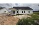New construction featuring white siding, black roof, covered patio, and a spacious unfinished lawn at 1008 Peedin Rd, Selma, NC 27576
