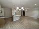 Open floor plan of kitchen with island, hardwood floors and modern chandelier lighting at 1008 Peedin Rd, Selma, NC 27576