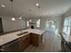 Bright kitchen with a center island and view of the fireplace and hardwood floors of the living area at 1008 Peedin Rd, Selma, NC 27576