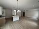 Open-concept living room with a kitchen island, wood-look flooring, and neutral decor at 1008 Peedin Rd, Selma, NC 27576