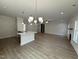 Open-concept living area featuring wood floors and elegant lighting at 1008 Peedin Rd, Selma, NC 27576