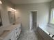 Main bathroom with dual vanity, quartz countertops, and a soaking tub at 1008 Peedin Rd, Selma, NC 27576