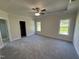 Spacious main bedroom with carpet, tray ceiling, fan, and two windows allowing for plenty of natural light at 1008 Peedin Rd, Selma, NC 27576