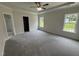 Large bedroom with tray ceilings, neutral carpet, and abundant natural light at 1008 Peedin Rd, Selma, NC 27576