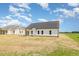 Rear exterior view of home with white siding, dark roof, and covered patio at 1008 Peedin Rd, Selma, NC 27576