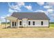 Rear exterior view of home with white siding, dark roof, and covered patio at 1008 Peedin Rd, Selma, NC 27576