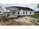 The rear of this home has a covered porch and white siding with black window trim at 1008 Peedin Rd, Selma, NC 27576