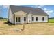 Rear exterior view of home with white siding, dark roof, and covered patio at 1008 Peedin Rd, Selma, NC 27576